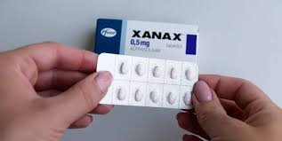 How long does Xanax take to kick in – person holding Xanax pill with clock background